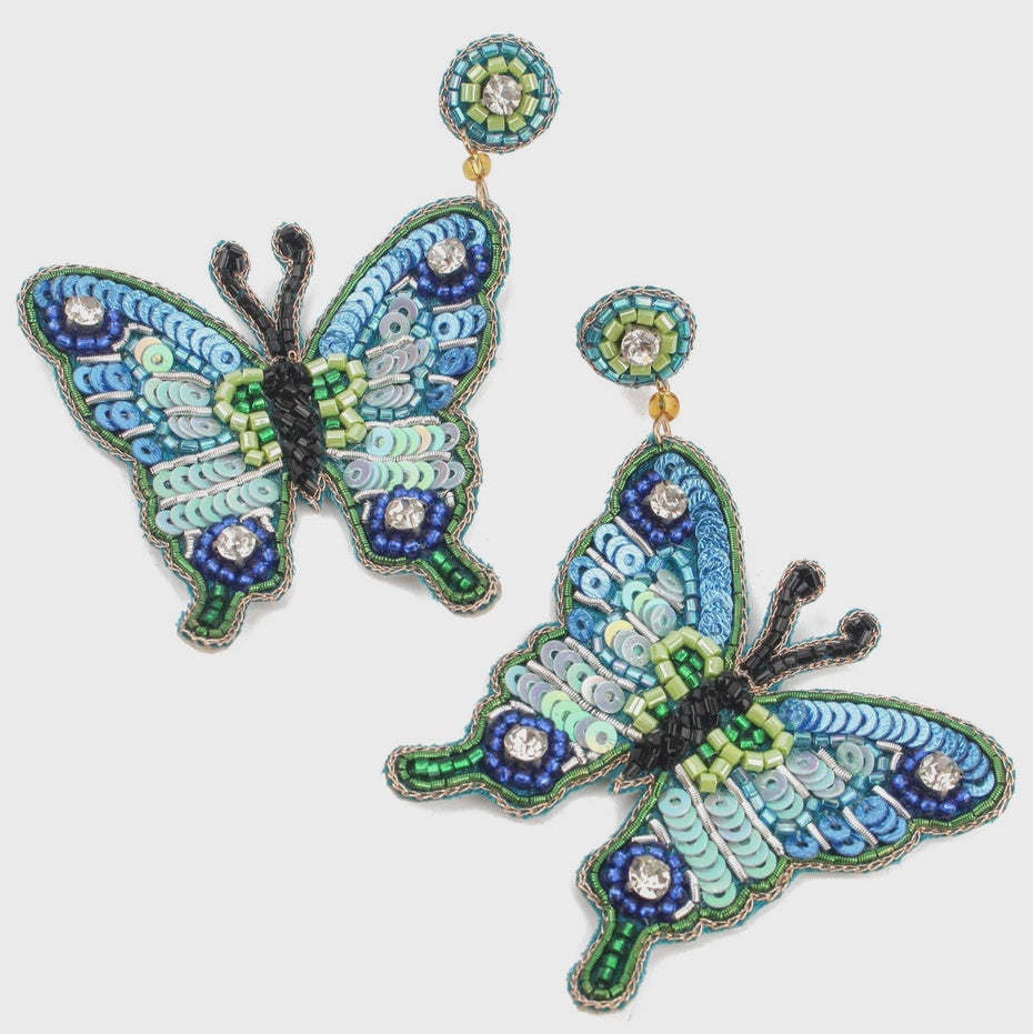 Butterfly-shaped earrings with intricate designs on a white background