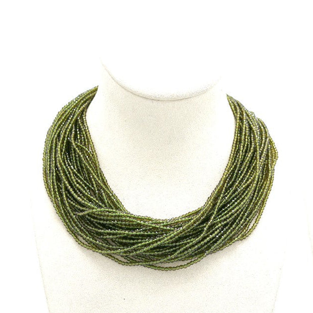 green necklace on mannequin busts 'Habana' logo.