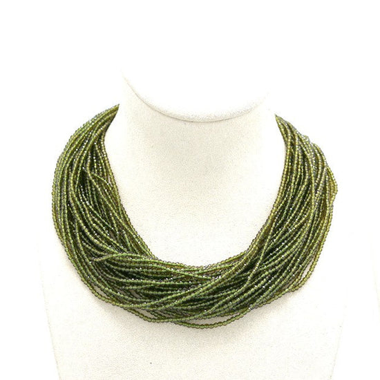 green necklace on mannequin busts 'Habana' logo.